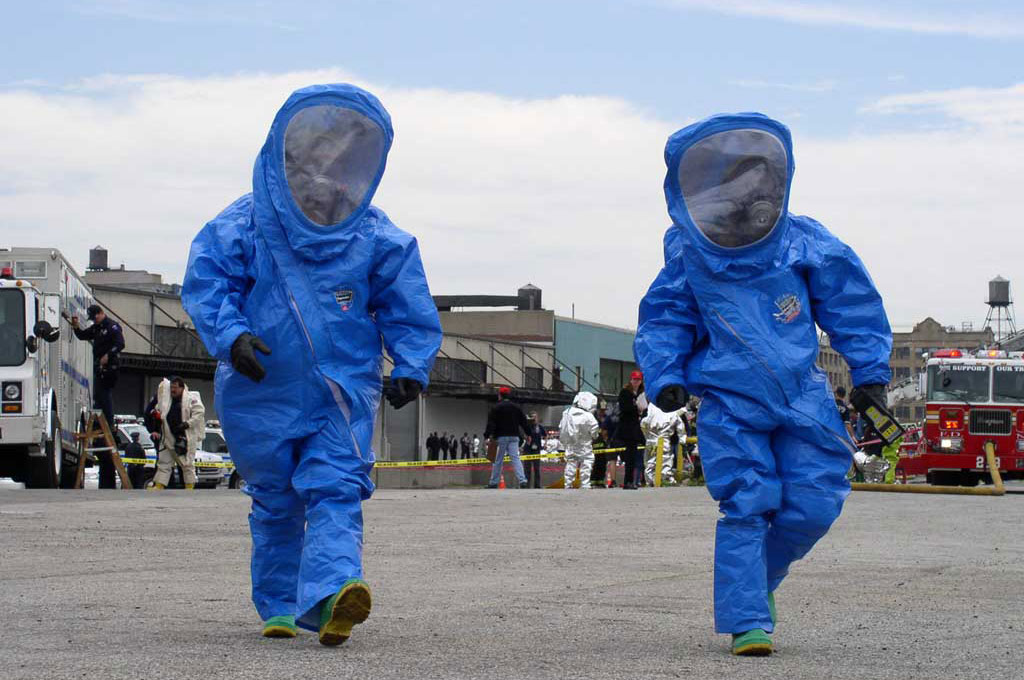 Two individuals wearing HAZMAT suits during a drill.