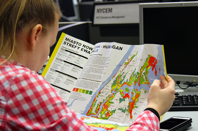 An individual reading the hurricane evacuation map in Polish.