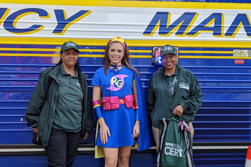 Ready Girl and two CERT volunteers stand in front of a NYCEM vehicle