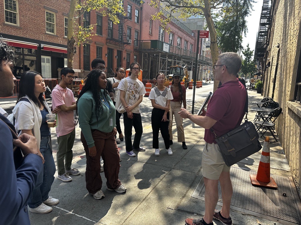 SYEP participants stand outside of Julius' Bar listening to NYC LGBT Historic Sites Project tour guide Ken Lustbader recall its rich history with the LGBTQ community.