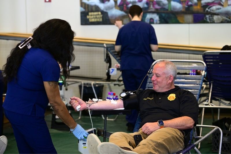 FDNY Commissioner Robert S. Tucker donates blood shortly after the competition with the NYPD got underway.