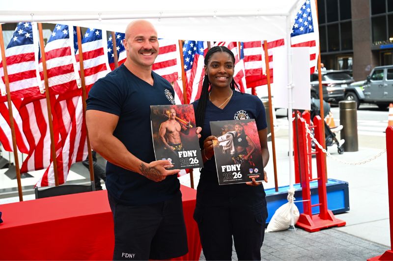 FDNY members who appear in the 2026 Calendar of Heroes show off their copies at the launch event on June 26, 2025.