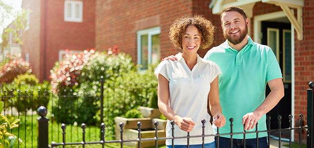 image of a woman and man standing in front of their home.