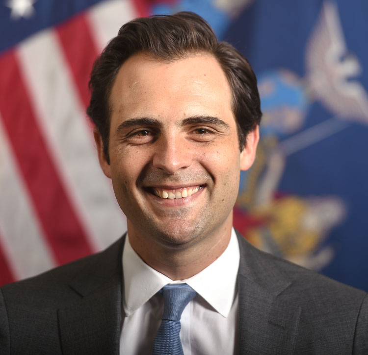 Michael R. Schmidt - Commissioner of the New York State Department of Taxation and Finance Photo headshot of Commissioner Michael R. Schmidt standing in front of the American flag