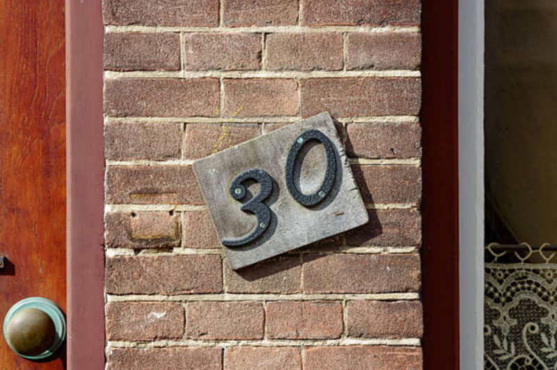 A plaque next to a door indicating the address is 30