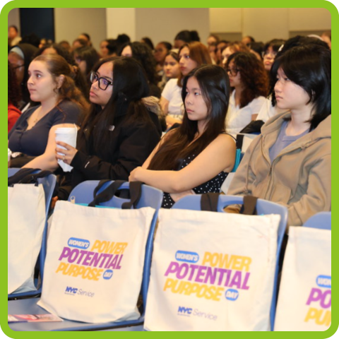 Mentees at an NYC Service summit watching a presentation