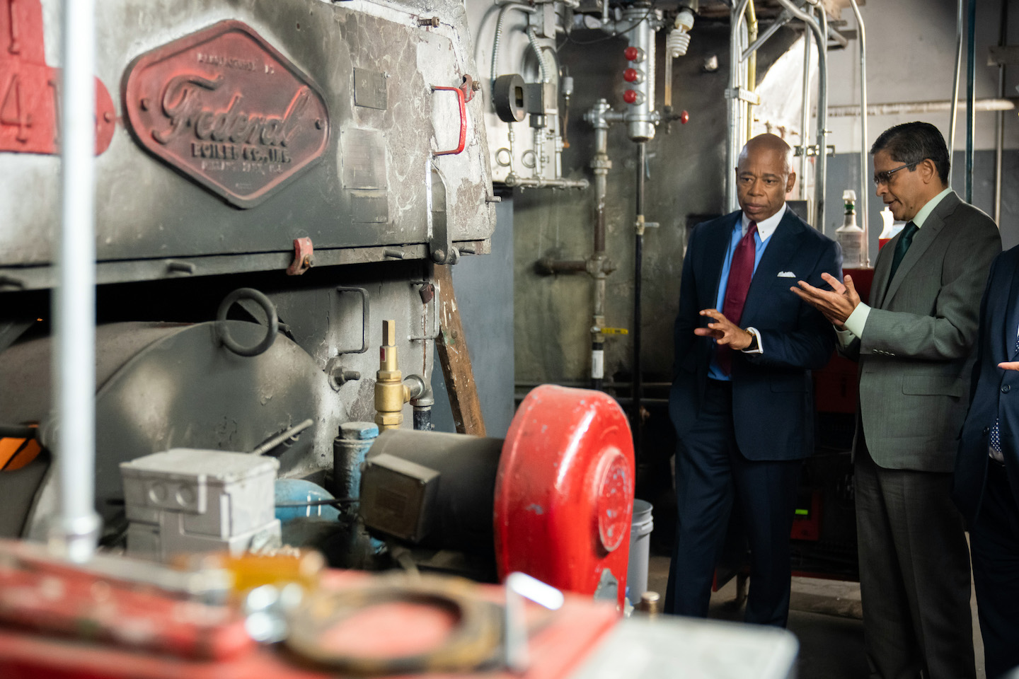 Mayor Adams and somebody else standing next to a boiler.