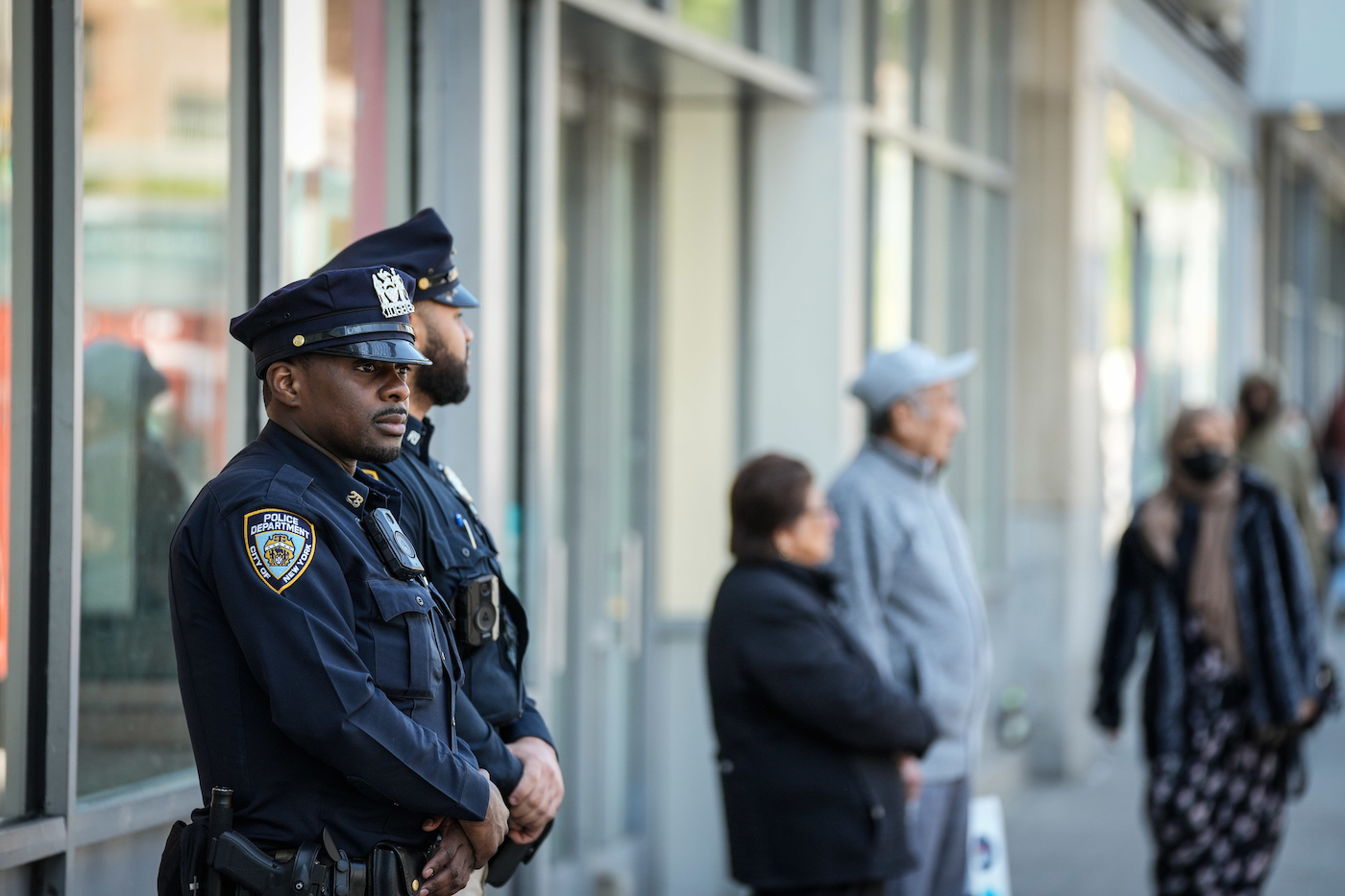 Two NYPD officers stand guard at a retail store in Harlem
                        