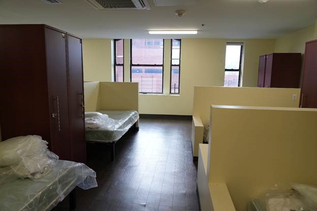A room with mutiple beds with semi privacy walls setup.