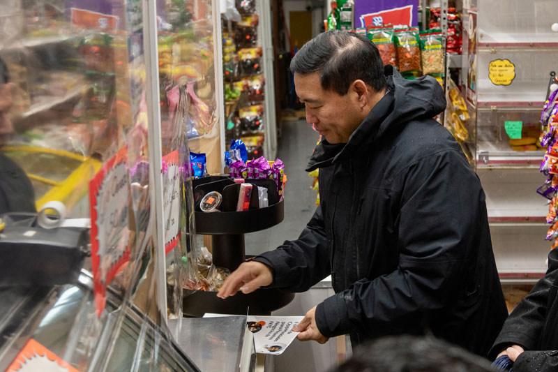 Commissioner Kevin D. Kim putting down a brochure at a store counter