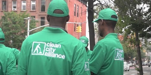 the back of two men with green shirts