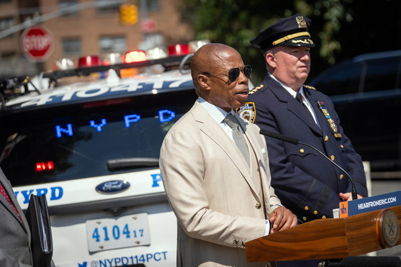 mayor adam in white suit speaking at public