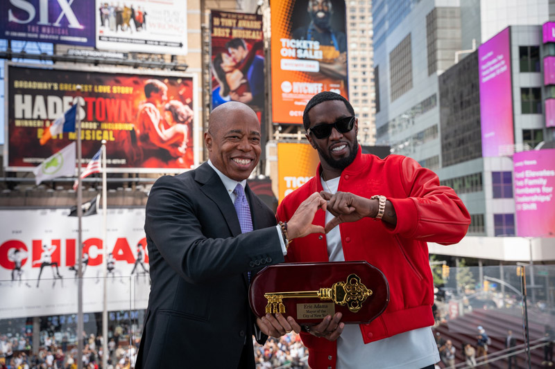 mayor adam and Sean “Diddy” Combs form a heart sign with their hands