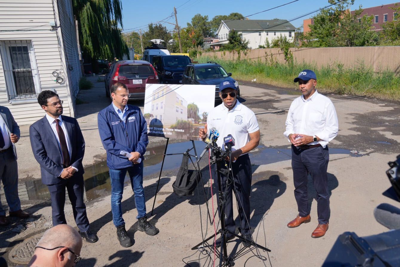 mayor adam accompanies by other officials is seen giving a public press briefing one the street