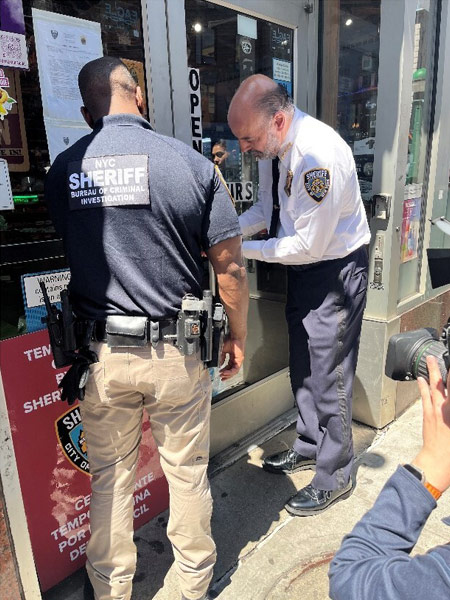Sheriff Miranda and members of law enforcement padlock a store unlawfully selling cannabis last week during “Operation Padlock to Protect.”