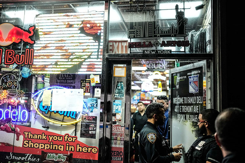 A group of police officer standing at the door of a daily store where it sells illegal weeds 