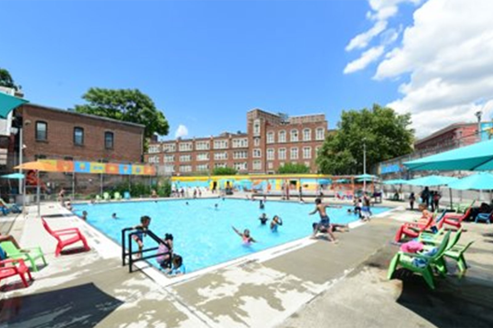 an outdoor community swimming pool with children swimming