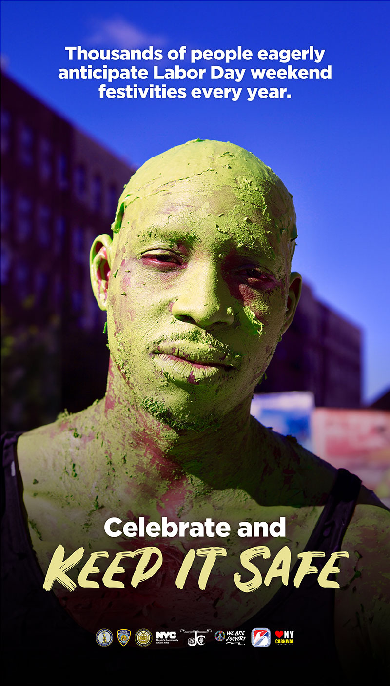 A man wearing sunglasses has part of his face and his clothing covered in pink dye. He's holding a giant conch shell, also dyed in multi-colors, up to his mouth in preparation to blow through it and make a noise like a horn. The text asks participants to celebrate Caribbean pride, culture and heritage, and to keep J'Ouvert safe.