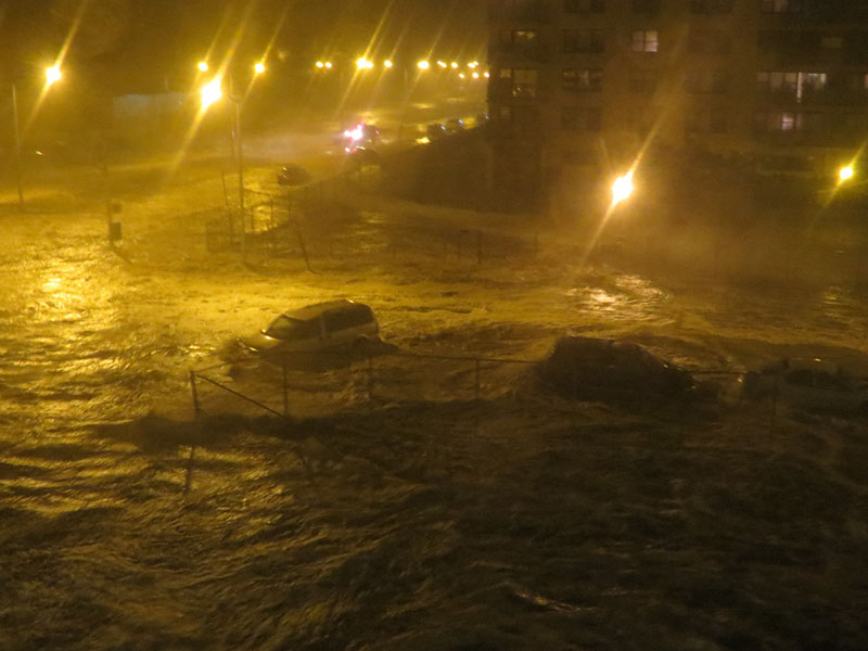 Car caught in street inundated by flooding water
