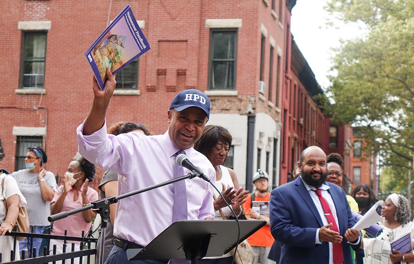 HPD Commissioner holding the Homeowner Handbook
                                           