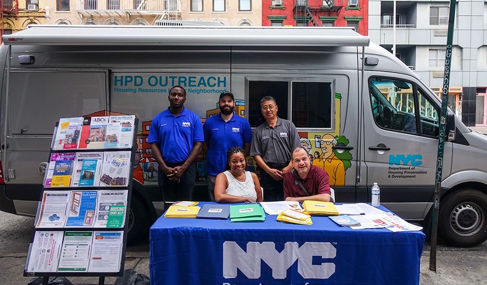 Photo of the HPD Outreach Van parked on the street with resources on a rack.