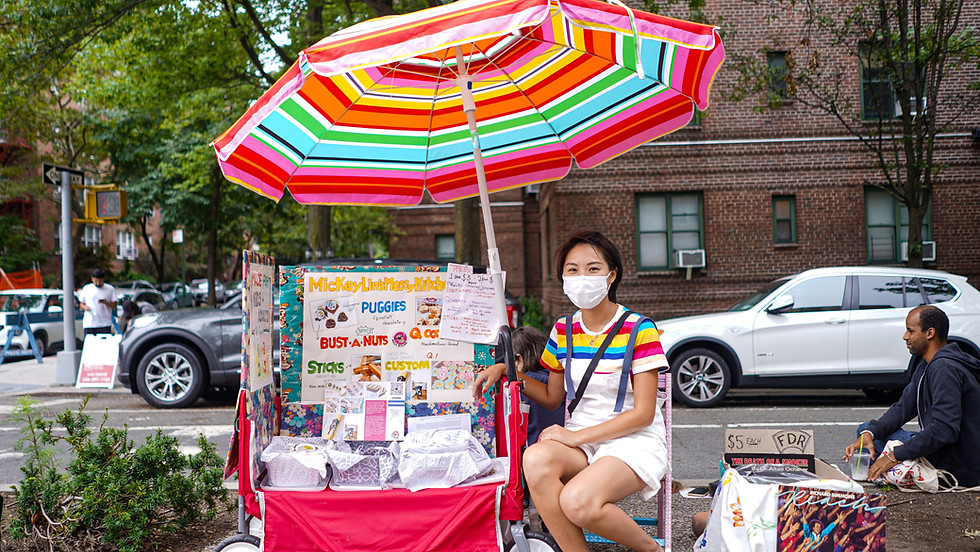 Asian woman sitting next to colorful street display