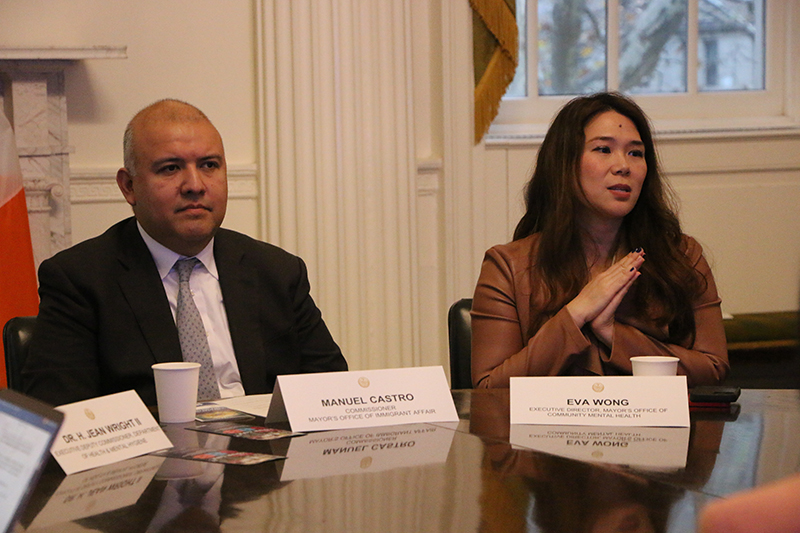 Two people sitting at a table. One woman is speaking.