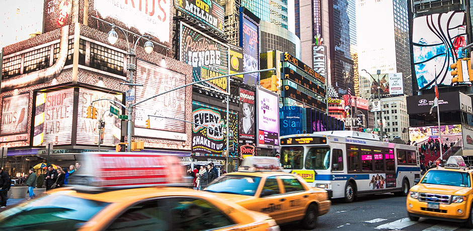 View of NYC Times Square with billboards and moving traffic
                                           