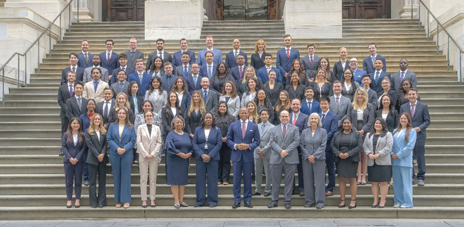mayor adam stands in the center, accompanied by a group of Assistant Corporation Counsels