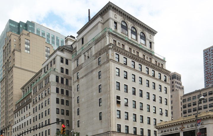 Color photo of tan Renaissance Revival-style building, streetlight in foreground