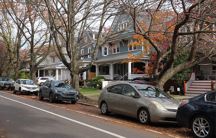 Photo of a block of homes with cars parked in front
                                           