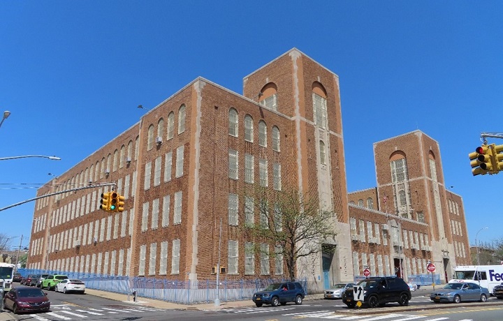 Outside of Gompers Industrial high school; a large brown building with school bu
                                           