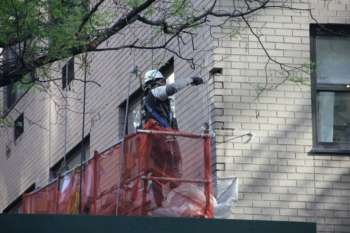 a worker is repairing the wall of a building