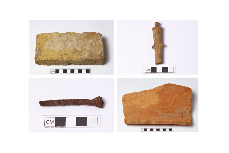 Image showing 4 historic artifacts, clockwise from top left: a yellow brick, a lead object, a red brick, and a rusted metal nail