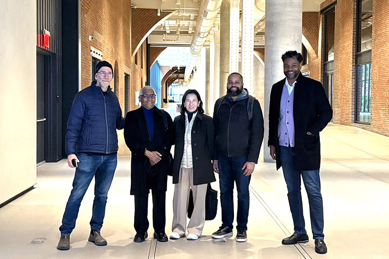 Color image of five people standing in historic building