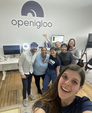 Selfie of Public Engagement Unit and open igloo staff in an office with an open igloo sign on the wall behind them.
