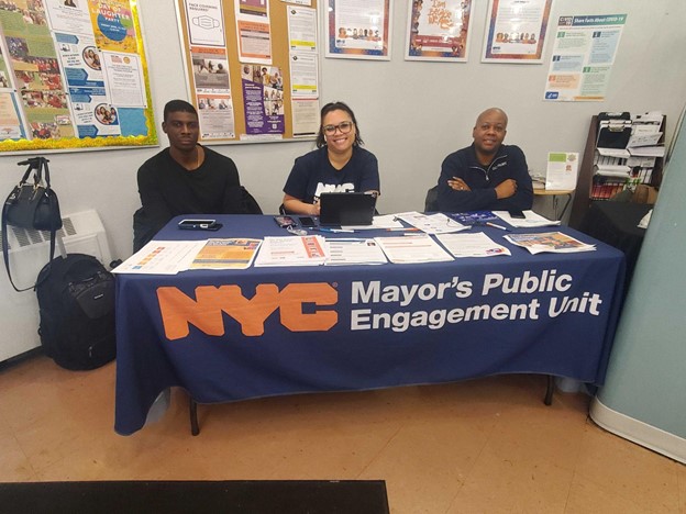 a group of three peu staff at a outreach site.