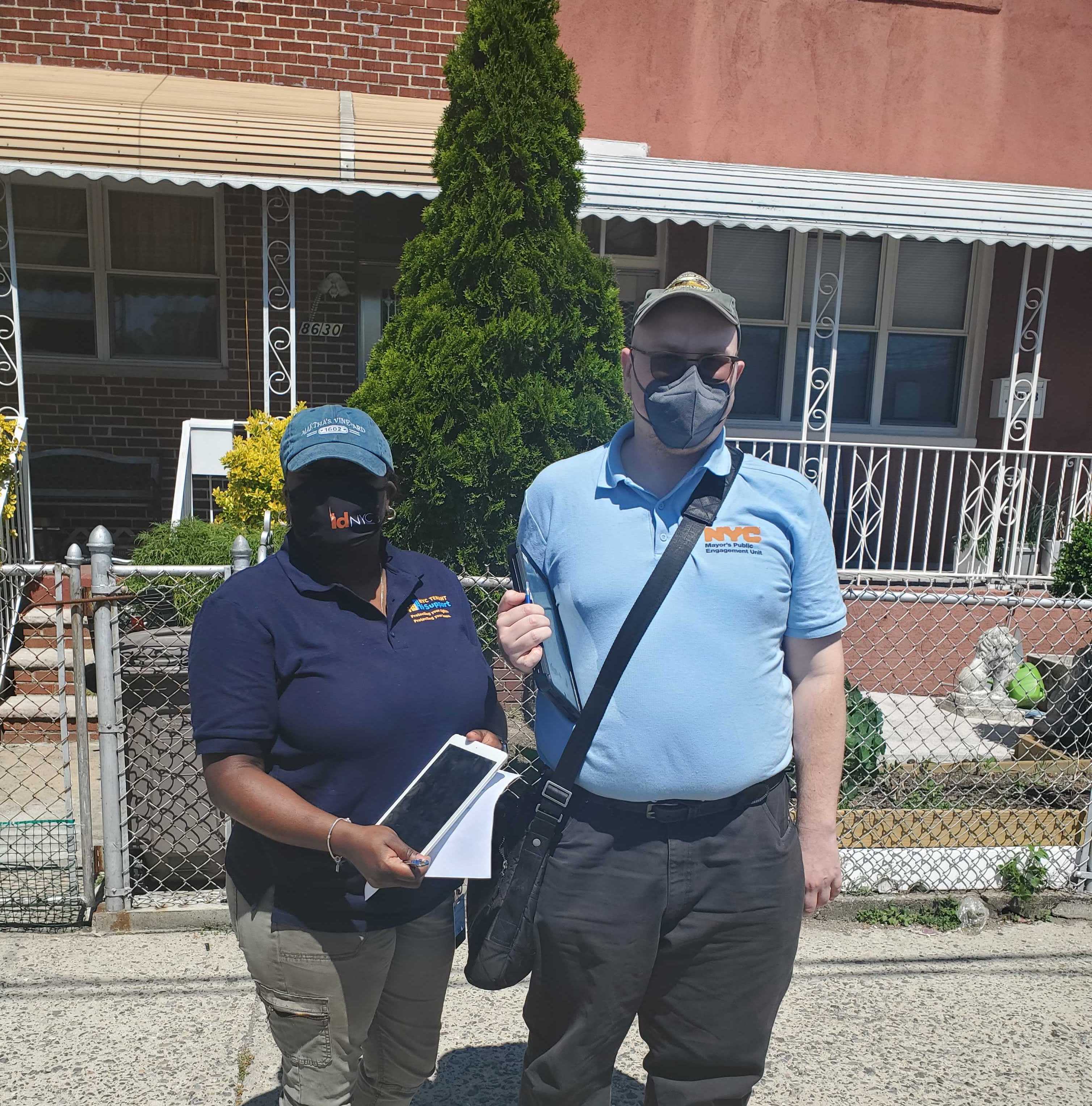 Two PEU staffers with an ipad and wearing masks.