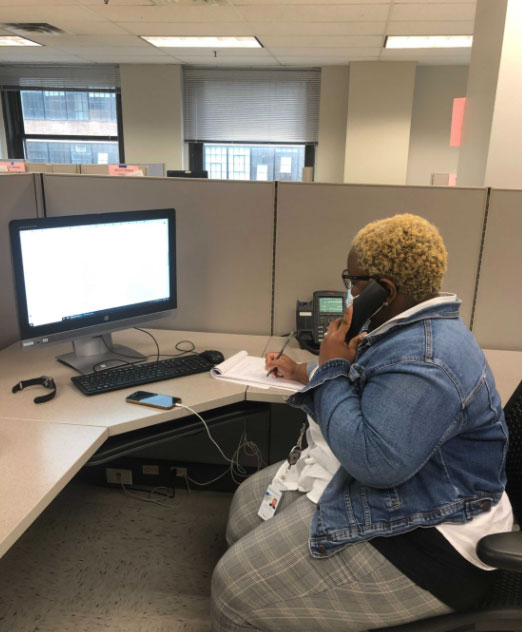 A woman is asking TSU helpline call in her cubicle