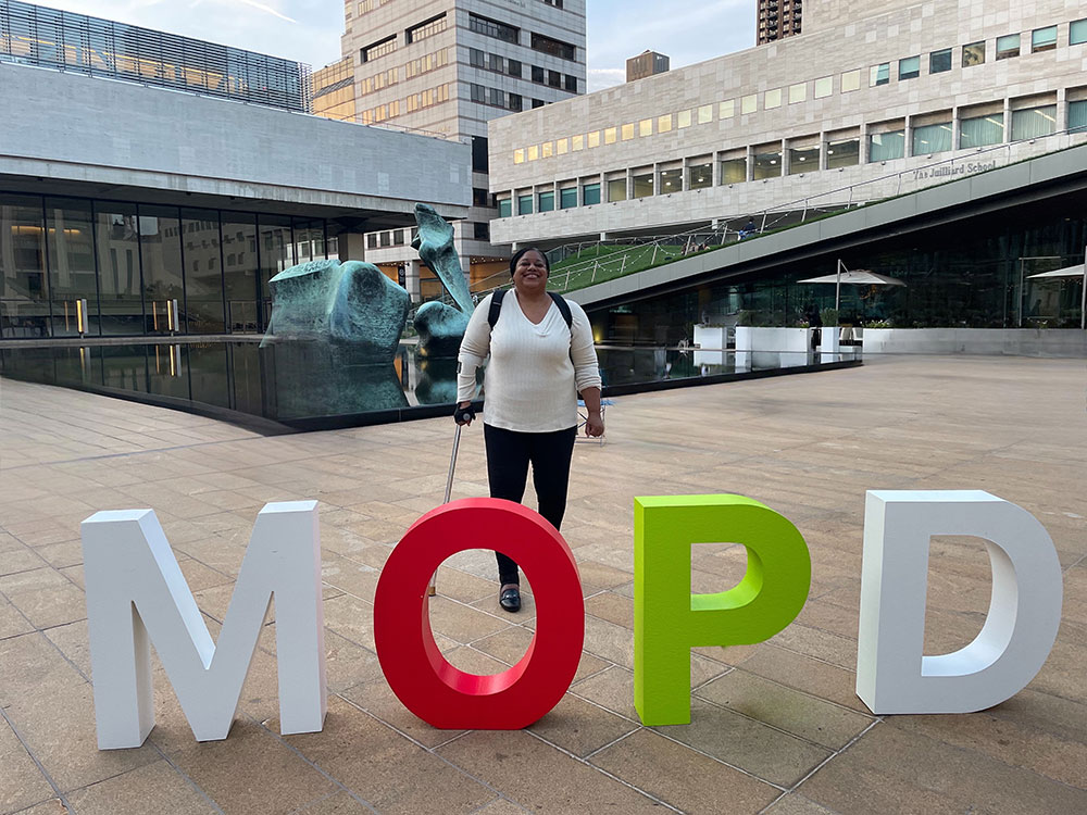 Photo of Commissioner Christina Curry behind the letters M O P D
