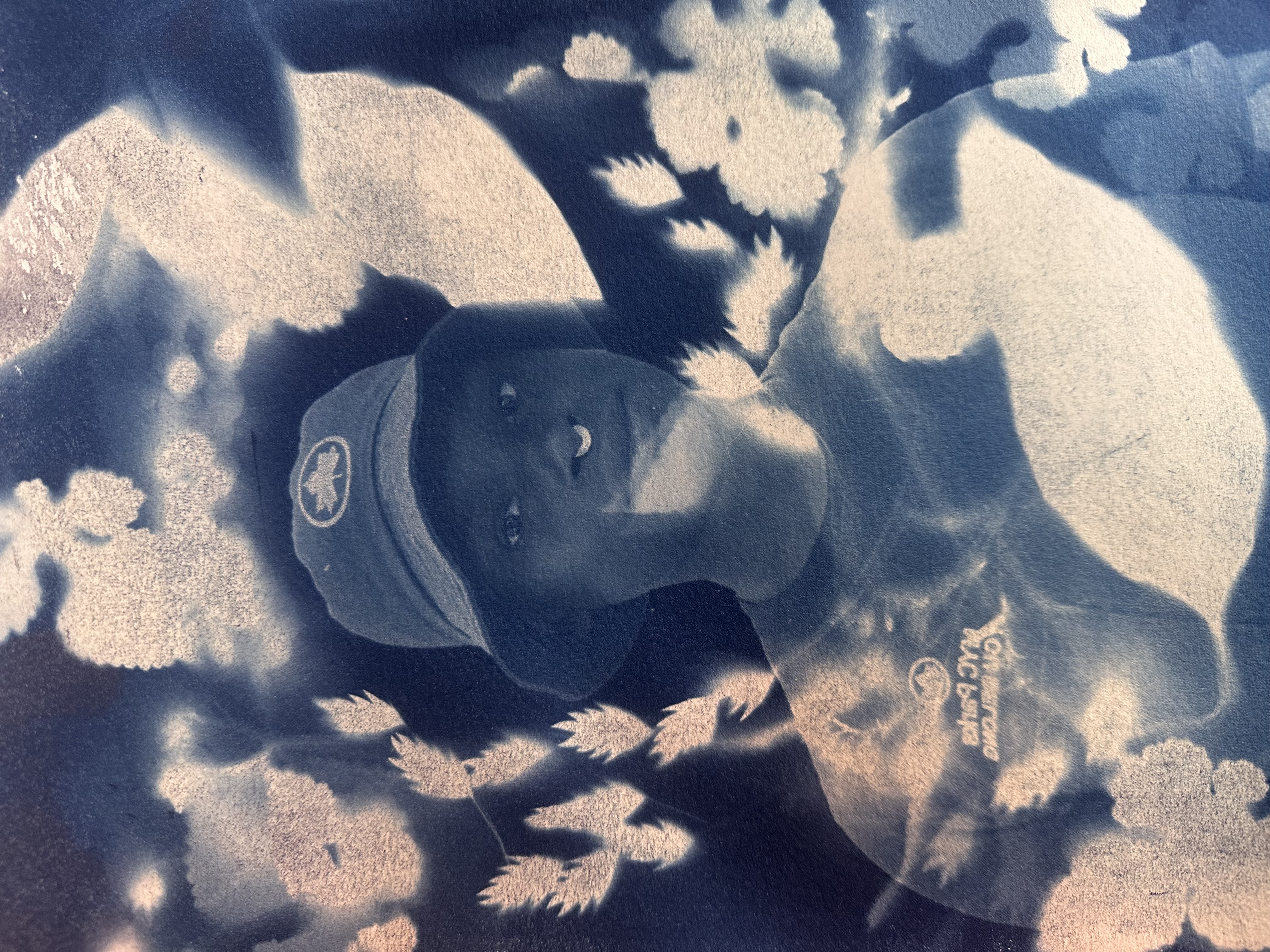 Rain, wearing a NYC Parks bucket hat with foliage encircling their face.