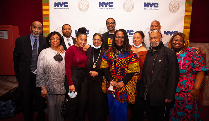 Eleven guests pose for a picture in front of a step & repeat.
                                           