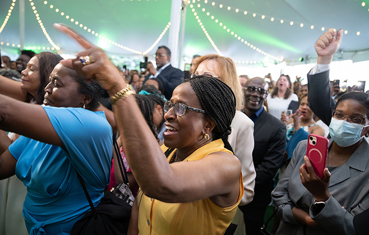 Attendees pointing and dancing to music. Some guests hold phones up to record performances