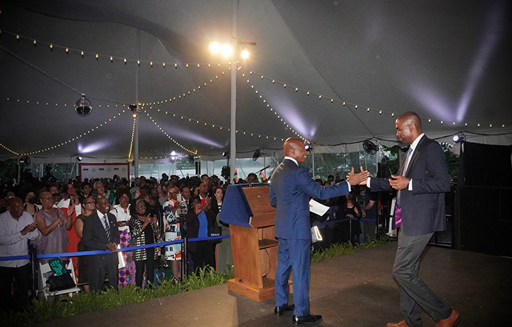 Mayor Adams and Lieutenant Governor Antonio Delgado shake hands on stage in front of a large crowd
