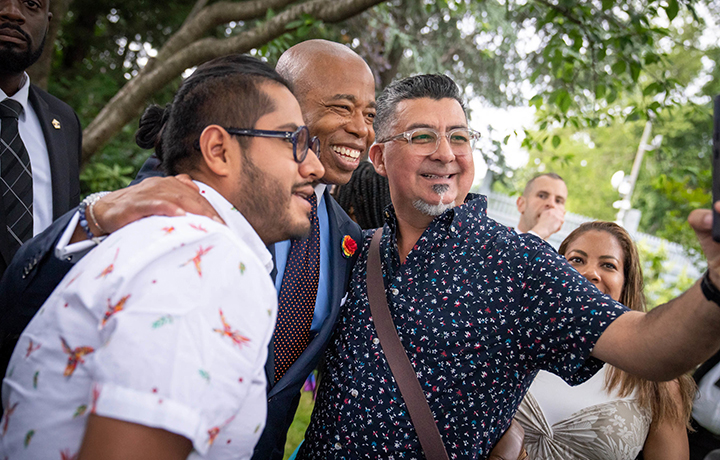 Two guests pose with smiles as they take a selfie with the Mayor