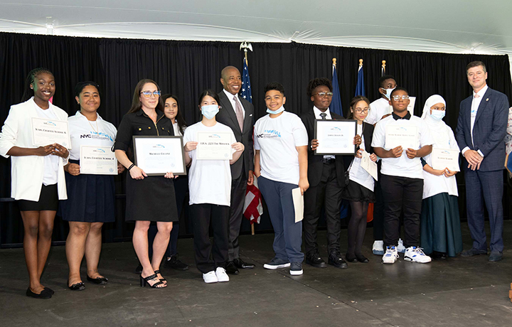Mayor Adams and Commissioner Ed Mermelstein, Mayor's Office for International Affairs, stand among the student representatives for the NYC Junior Ambassadors program