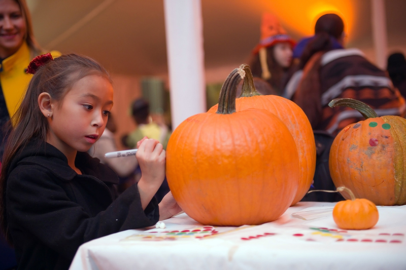 girl designing pumpkin at Gracie Mansion Halloween