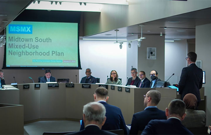 A person speaks from a podium at a City Planning Commission meeting
                                           