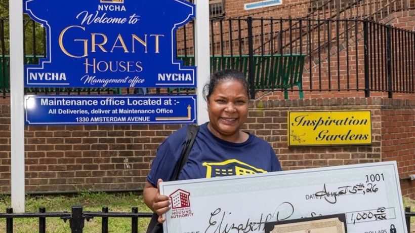 Caretaker Elizabeth Reynoso smiling while holding a $1,000 John DeCarlo award check and award certificate.
                                           