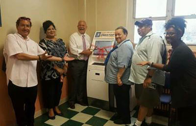 NYCHA General Manager (Third Left) and Tenant Association President Carol Wilkins (Third Right) unveil NYCHA’s new kiosks with Property Manager Anita Lal (Second Left) and staff from Congresswoman Maloney, Assembly Member Nolan and State Senator Gianaris’s offices.